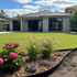 black metal garden edging by YardSteel Australia installed in front of a green lawn and brick house
