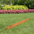 Rust-coloured metal garden border by YardSteel on grass with flowers in the background