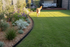 Small black steel garden edging in A modern Australian backyard with a dog in the background